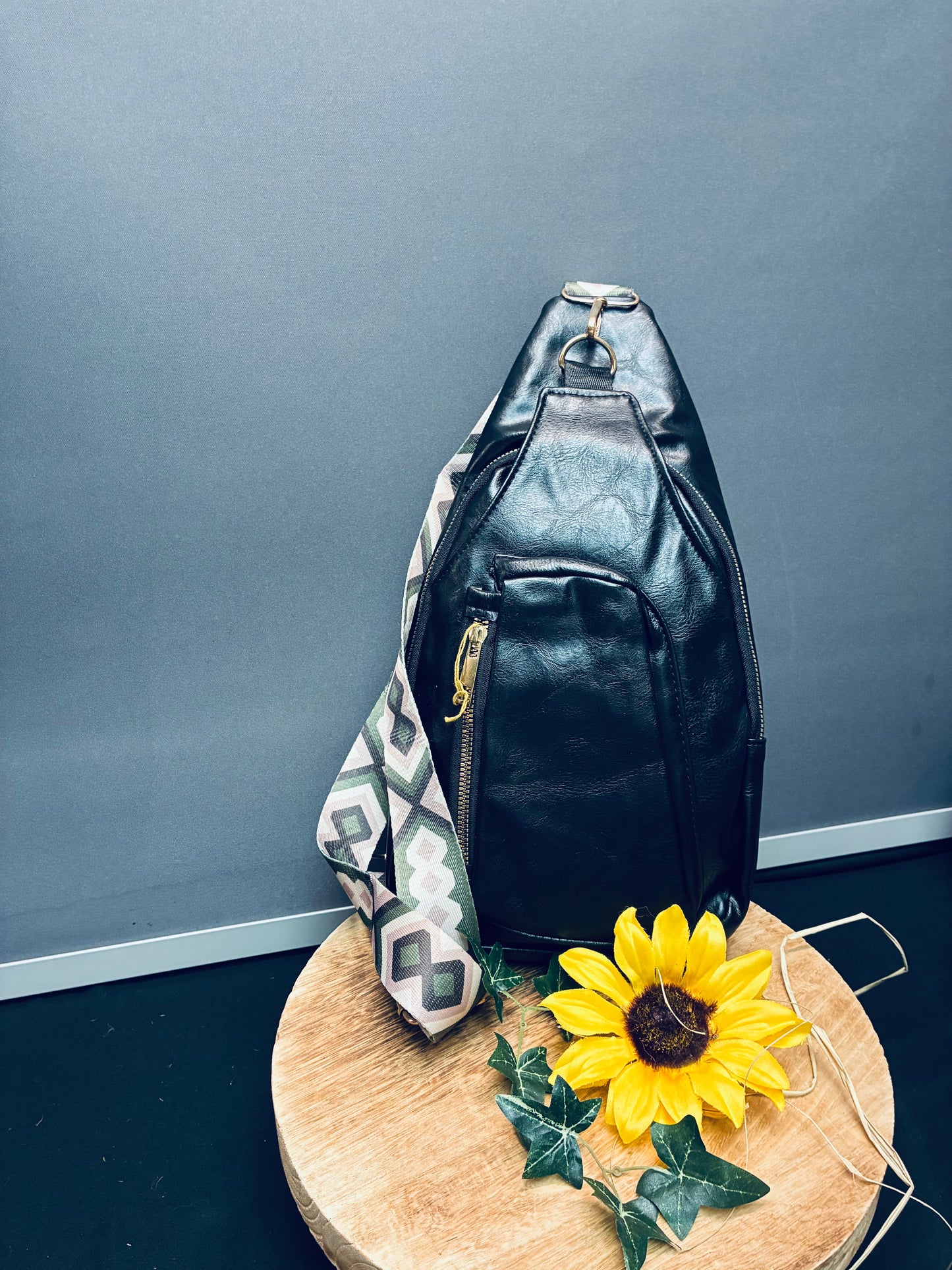 Blk sling bag with green and pink pattern strap